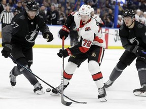 Tampa Bay Lightning defenseman Victor Hedman (77) knocks the puck away from Ottawa Senators defenseman Thomas Chabot (72) during the third period of an NHL hockey game Saturday, March 2, 2019, in Tampa, Fla. Trailing the play is Lightning defenseman Mikhail Sergachev (98).