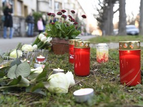 Flowers lay on the sidewalk where a 7-year old boy was stabbed on his way back from school in the Sankt Galler Ring area of Basel, Switzerland, Thursday March 21, 2019. (Georgios Kefalas/Keystone via AP)