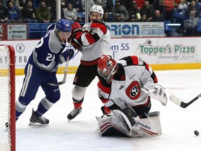 Ottawa 67's goalie Mikey DiPietro looks for the puck behind him while Merrick Rippon ties up the Sudbury Wolves' Drake Pilon during Game 4 at the Sudbury Community Arena on Thursday April 11, 2019.