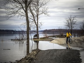 The low lying areas around Ottawa and Gatineau were hit with the beginning of the flooding near the rivers, Sunday, April 21, 2019. Gatineau city crews were out trying to save boulevard Hurtubise to keep one lane open for residents and emergency vehicles Sunday afternoon. The Ottawa River has flooded the many parts of the road. A cyclist stops at the edge of a flooded area.