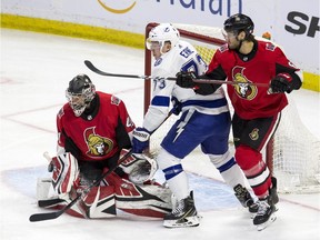 Ottawa Senators goaltender Craig Anderson makes a save as Sens defence man Christian Wolanin defends against Tampa Bay Lightning Adam Erne during NHL hockey action at Canadian Tire Centre in Ottawa on on April 1, 2019.