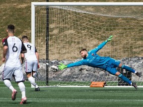 Ottawa Fury FC teammates Chris Mannella (6) and Carl Haworth (9) watch as goalkeeper Callum Irving makes a diving save on a shot by Loudoun United during a United Soccer League Championship match at TD Place stadium in Ottawa on Saturday, April 12, 2019. Ottawa won the match 2-0.