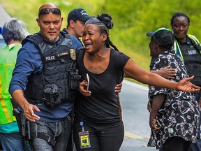 A woman believed to be related to ones involved in a hostage situation reacts as law enforcement on the scene tried to console them in Stockbridge, Ga., Thursday, April 4, 2019.