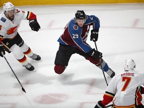 Colorado Avalanche center Nathan MacKinnon, center, drives to the net between Calgary Flames defensemen Oscar Fantenberg, left, and TJ Brodie in the first period of Game 3 of a first-round NHL hockey playoff series Monday, April 15, 2019, in Denver. (AP Photo/David Zalubowski) ORG XMIT: CODZ106