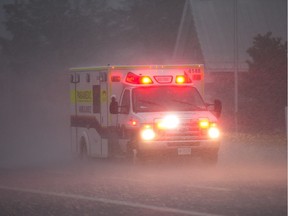 An ambulance races through the rain.