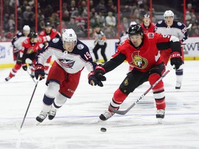 Columbus Blue Jackets centre Ryan Dzingel chases the puck as Ottawa Senators defencemen Cody Ceci defends during first period NHL hockey action in Ottawa on April 6, 2019.