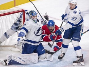 Canadiens centre Nate Thompson (21) is sandwiched between Lightning goaltender Edward Pasquale (80) and defenceman Ryan McDonagh (27) during the third period of Tuesday's game in Montreal.