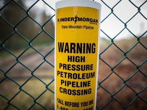 A sign warning of an underground petroleum pipeline is seen on a fence at Kinder Morgan's facility where work is being conducted in preparation for the expansion of the Trans Mountain Pipeline, in Burnaby, B.C., on April 9, 2018.