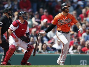 Baltimore Orioles' Chris Davis watches his two-run single in front of Boston Red Sox's Christian Vazquez during the first inning of a baseball game in Boston, Saturday, April 13, 2019.