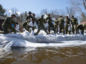 Canadian Forces members build a wall of sandbags to protect a home from the flooding Ottawa River in the Ottawa community of Constance Bay, on Tuesday, April 30, 2019.