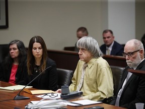 David Turpin, second from right, and wife, Louise, far left, sit in a courtroom with their attorneys, Allison Lowe, second from left, and David Macher Friday, Feb. 22, 2019, in Riverside, Calif. The California couple who shackled some of their 13 children to beds and starved them have pleaded guilty to torture and other abuse.