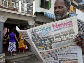 A man reads a newspaper with a lead story on Islamic State taking responsibility of Easter Sunday terror attacks in Colombo, Sri Lanka, Wednesday, April 24, 2019.