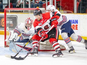 Ottawa 67's forward Sasha Chmelevski protects the puck from the Oshawa Generals' Allan McShane, right, and goalie Kyle Keyser as he circles the net  during an Ontario Hockey League Eastern Conference final playoff game at TD Place arena on Saturday, April 20, 2019. Ottawa won the game 7-4 to take a 2-0 lead in the best-of-seven series.