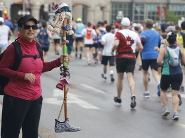 A woman watches runners during the marathon at the Ottawa Race Weekend on Sunday, May 26, 2019.