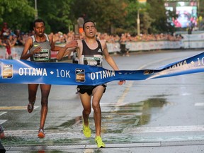 Mohammed Ziani of Morocco (R) just beats Yitayal Atnafu (L) of Ethiopia to finish first with a time of 28:36.5 during the 10K run, held in downtown Ottawa, during the Tamarack Ottawa Race Weekend, on May 28, 2016.