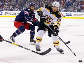 Brad Marchand of the Boston Bruins moves the puck past Boone Jenner of the Columbus Blue Jackets during the first period in Game 3.