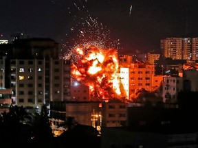 An explosion is pictured among buildings during an Israeli airstike on Gaza City on May 4, 2019. (MAHMUD HAMS/AFP/Getty Images)