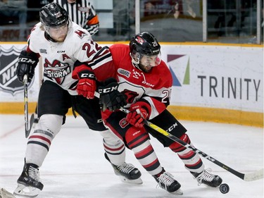 Ottawa's Lucas Chiodo (right) gets ahead of Guelph's Jack Hanley to get on the puck behind Guelph's net.