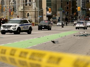 Ottawa Police block off the area where a cyclist was struck on Laurier Avenue near Elgin Street Thursday.