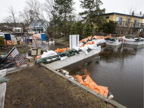 Flood waters are held at bay by the concrete wall of the Britannia berm on Jamieson Street in Ottawa on May 1, 2019.  It will be weeks yet before a massive clean-up effort can begin in flood-damaged areas.