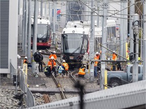 OC Transpo employees work on a train that derailed in the yards at 825 Belfast Road on Friday. ( Errol McGihon/Postmedia)