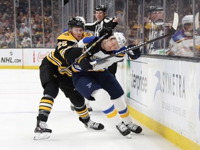 St. Louis Blues' Jay Bouwmeester gets checked by Boston Bruins' Brandon Carlo during Monday's game. (GETTY IMAGES)