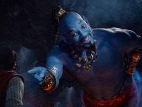 This image released by Disney shows Mena Massoud as Aladdin, left, and Will Smith as Genie in Disney's live-action adaptation of the 1992 animated classic "Aladdin." (Disney via AP)