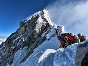 (FILES) In this file handout photo taken on May 22, 2019 and released by climber Nirmal Purja's Project Possible expedition shows heavy traffic of mountain climbers lining up to stand at the summit of Mount Everest. - Three more climbers have died on Everest, expedition organisers and officials said on May 24, taking the toll from a deadly week on the overcrowded world's highest peak to seven.