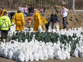 The community of Constance Bay gets busy filling sandbags and using them to protect their homes in anticipation of rising water from the Ottawa River.