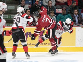 Merrick Rippon of the 67’s collides with Storm’s Zachary Roberts as Tye Felhaber gets his guard up in Game 4 last night in Guelph.                                                GAR FITZGERALD/PHOTO