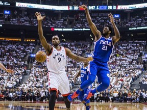 Raptors’ Serge Ibaka (left), sporting a bandage after getting an accidental Kawhi Leonard elbow to the head, defends against Sixers’ Joel Embiid during Game 5 on Tuesday.  Ernest Doroszuk/Toronto Sun