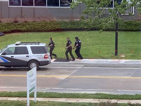 Armed police officers and others are seen outside STEM School Highlands Ranch, a charter middle school in the Denver suburb of Highlands Ranch, Colo., after a shooting Tuesday, May 7, 2019. Authorities said several people were injured and a few suspects were in custody.