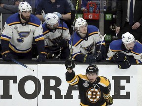 Blues players on the bench watch as the Bruins' Brad Marchand celebrates his empty-net goal during the third period in Game 1 on Monday night.