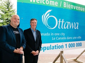 Ottawa Tourism CEO and president Michael Crockatt and Ottawa Mayor Jim Watson unveil a sign boasting the city's one million-plus population and its new slogan, Canada in One City.