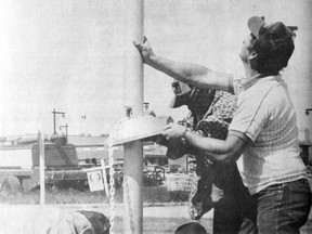 June 26, 1985 Vulcan Advocate file photo The 31 flags that will be raised this Dominion Day as part of the Fly a Flag project at Vulcan, had concrete bases poured last week and Monday the task of erecting poles began. Aluminum flag poles were taken from their crates, assembled with their caps, covers and interior lanyards, and finally, with three men on guy ropes, the first was raised above, at the town entrance, where 16 flags will be flown. Four bolts hold the pole secure and this pole was in an immediate wind test. “We’ve put up a couple of other similar poles and they’ll handle our winds”, said town worker Alf Daw. From the left are flag project chairman Pat Roe, town staff Henry Dyck and Daw, and town foreman Harold Lewis.