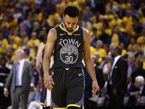 Warriors guard Stephen Curry hangs his head during Friday's loss to the Raptors. (GETTY IMAGES)