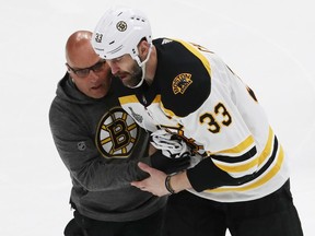 Bruins captain Zdeno Chara is assisted off the ice after being struck in the face by the puck during Game 4 of the Stanley Cup final against the Blues in St. Louis on Monday night.