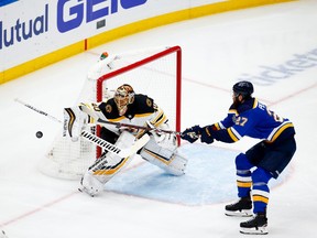 Alex Pietrangelo of the Blues and Bruins netminder Tuukka Rask reach for the flying puck during Game 4 in St. Louis on Monday night.