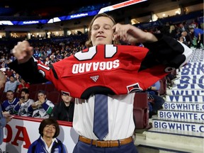 Mads Sogaard pulls on a Senators jersey after being selected 37th overall on Saturday in Vancouver.