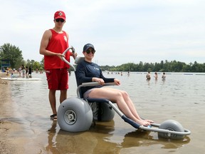 Xavier Latreille, Waterfront lifeguard and Jessica Andersen, beach operational support staff show the accessible beach chair at Mooney's Bay.