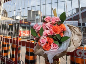 Flowers left in tribute as a bus passes through the station as commuters and traffic gets back to normal at the Westboro Station near Tunney's Pasture following the horrific bus crash on Jan. 11.