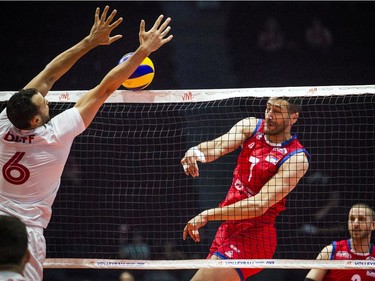 Serbia's Petar Krsmanovic (7) spikes the ball toward Canada's Justin Duff (6).