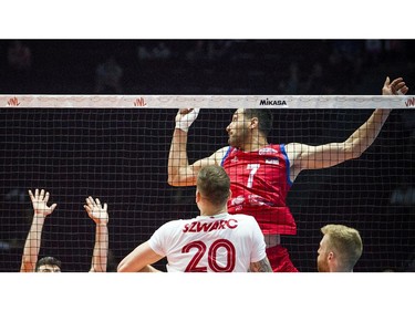 Serbia's Petar Krsmanovic watches the ball careen off a Canadian block at the net.
