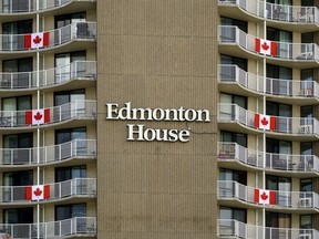Canada flags adorn the exterior of Edmonton House, a residential highrise apartment complex in downtown Edmonton, on Friday.