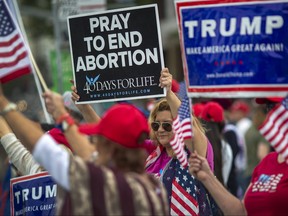 A woman holds an anti-abortion placard as supporters of President Donald Trump rally outside the Wilshire Federal Building on June 2, 2019 in Los Angeles, California.