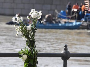 Flowers have been left by the river as the search for the missing boat passengers continues on June 4, 2019 following a boat accident on the Danube river in Budapest. - Hungarian police confirmed the discovery of two more victims of a sightseeing boat's collision with a river cruise ship in Budapest last week raising the toll to nine tourists killed. Only seven of the 35 people on board have survived so far, leaving 19 still missing with the prospect of finding any more passengers alive seen as very slim.