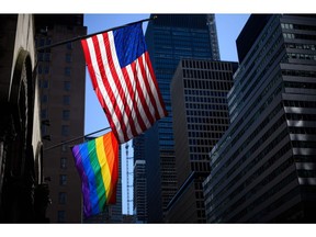 A rainbow flag and a US flag are seen in front of the St Bartholomew's Church on June 11, 2019 in New York City.