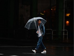 A man walks with an umbrella.