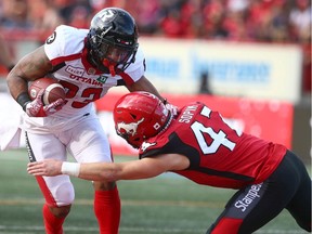 Ottawa Redblack Mossis Madu is tackled by Stampeder Fraser Sopik during CFL action between the Ottawa Redblacks and the Calgary Stampeders in Calgary on Saturday, June 15, 2019.