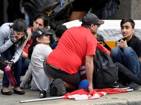 People take cover after reports of shots fired in the area where crowds gathered in Toronto's Nathan Phillips Square to celebrate the Raptors victory parade on Monday.